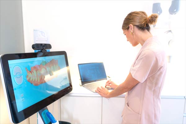 A-dentist-looking-at-the-3d-xray-on-a-clients-monitor-on-the-computer-in-the-modern-dental-clinic-600px