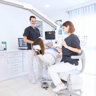 Female dentist scanning patient's teeth with x-ray-machine at modern dental clinic